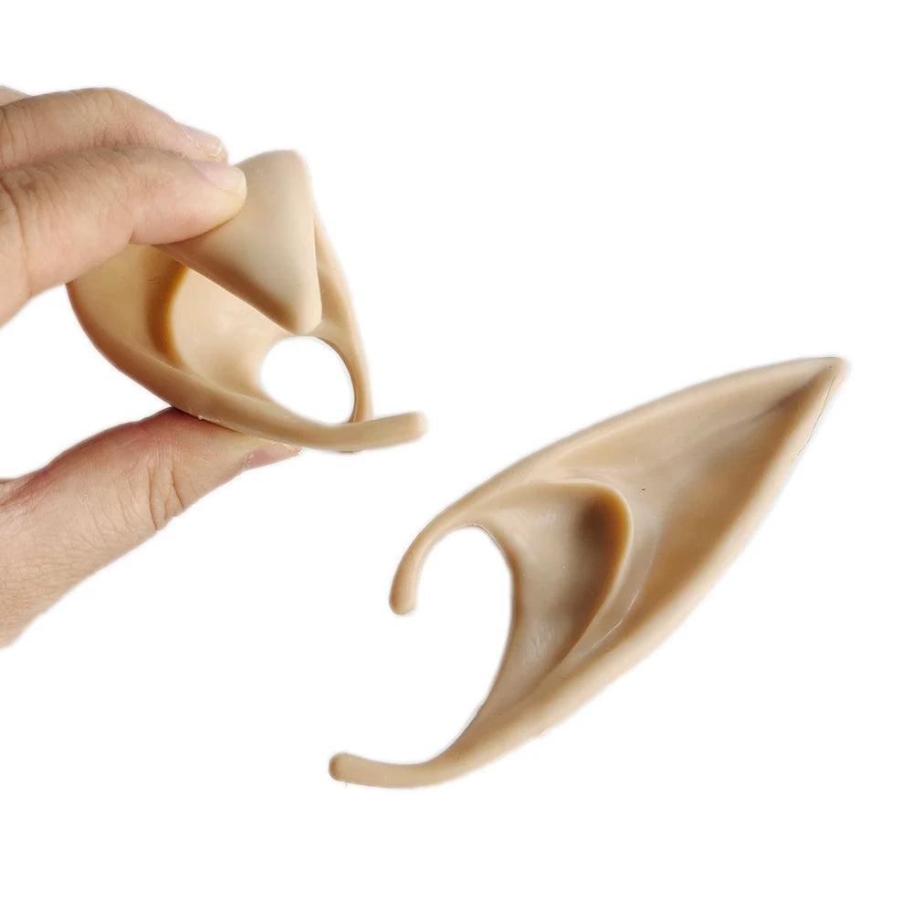 Beige silicone ear tips being held by a hand on a white background