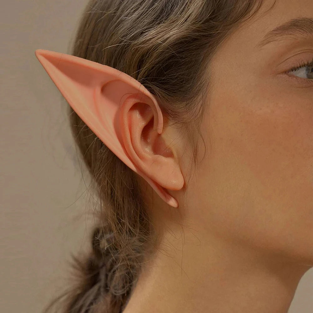 Close-up of a person wearing pink elf ears against a neutral background
