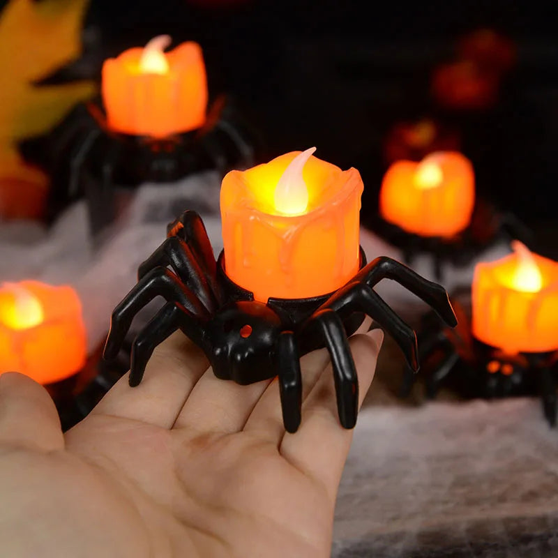 Spider-shaped candle holder with a lit candle, surrounded by other similar candles on a dark background.