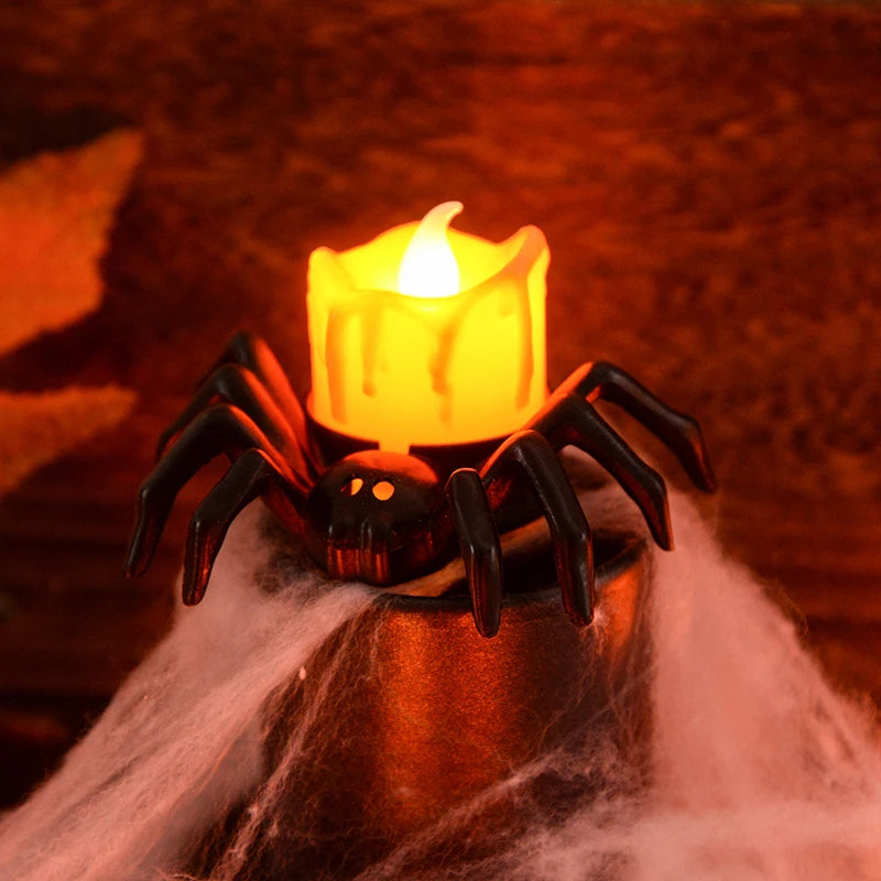 Spider-shaped candle holder with a lit candle on a dark background