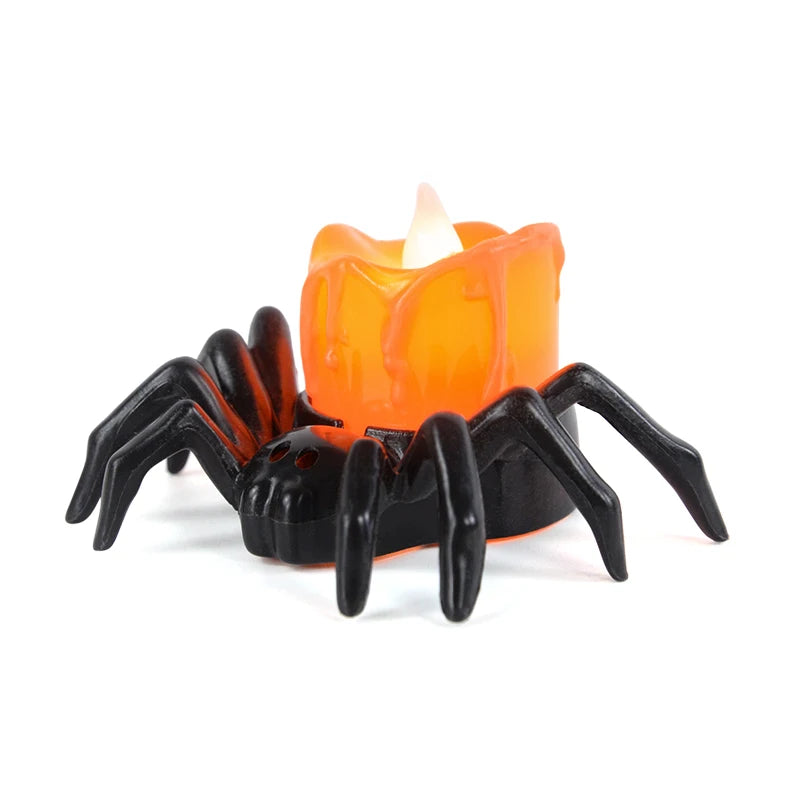 Spider-shaped candle holder with a lit orange candle on a white background