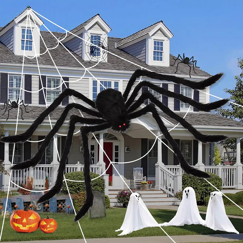 Halloween decorations including a large spider, webs, ghosts, and pumpkins in front of a house.