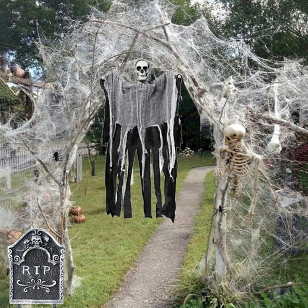 Halloween decorations with skeletons and spider webs in a yard.