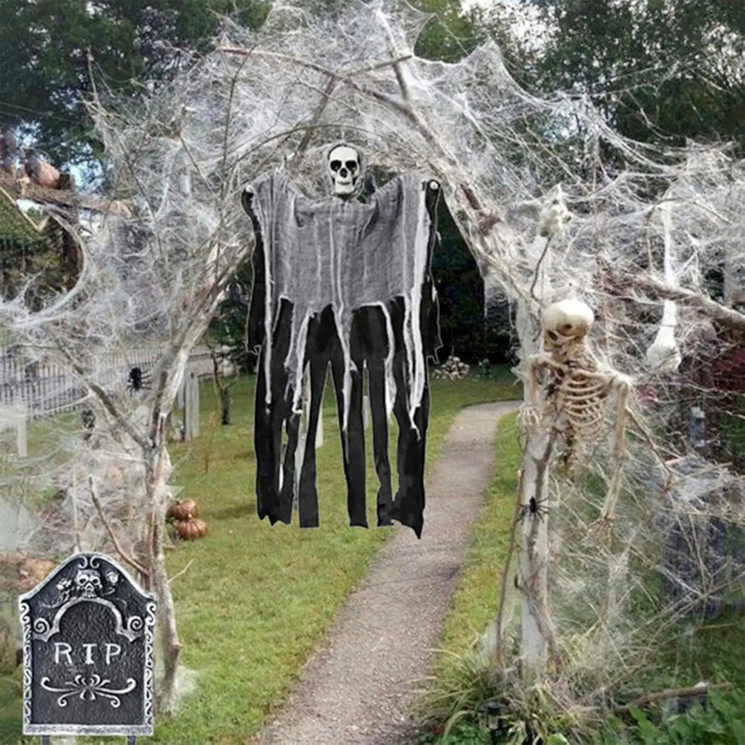 Halloween decorations with skeletons and spider webs in a yard.