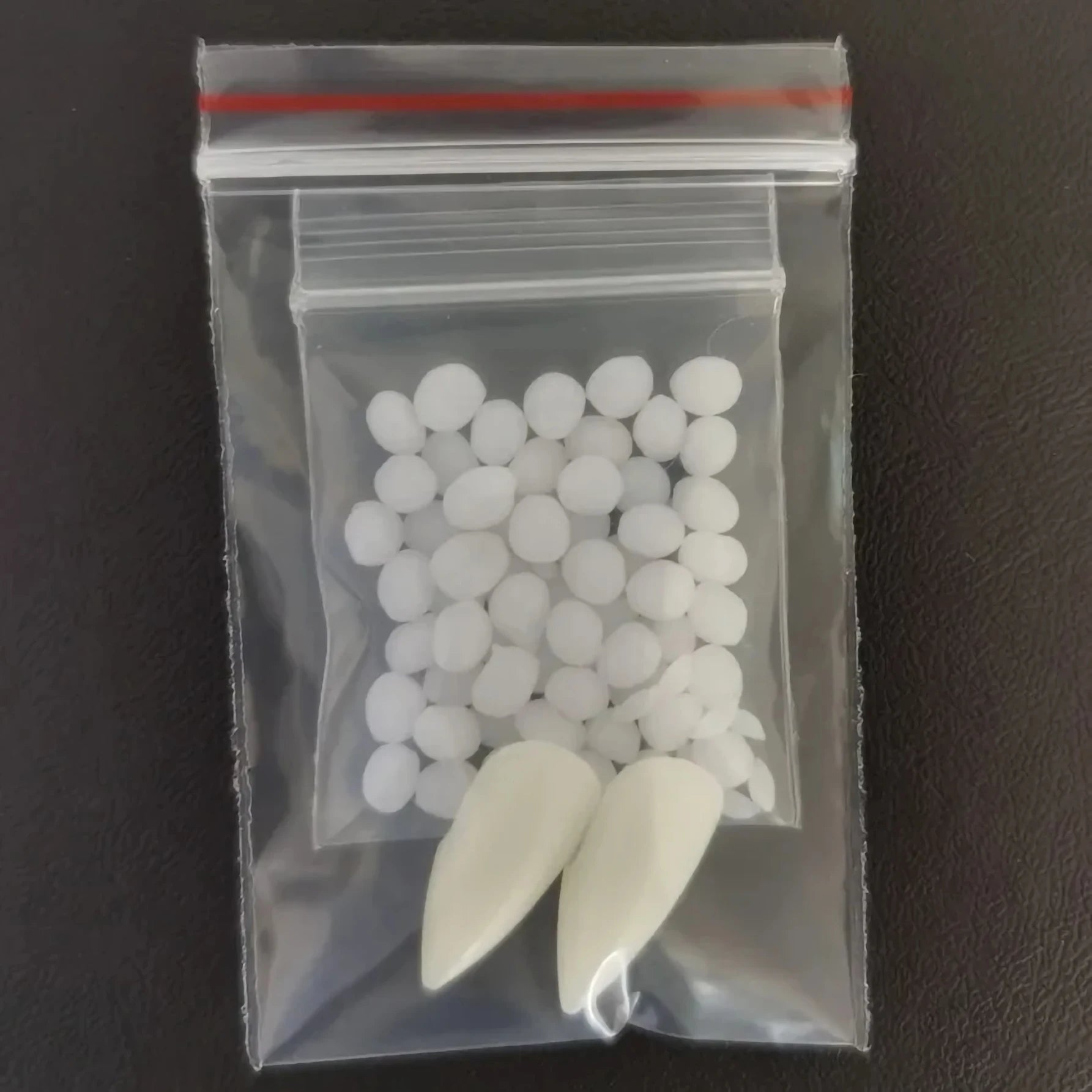 Clear plastic bag with white objects on a dark surface