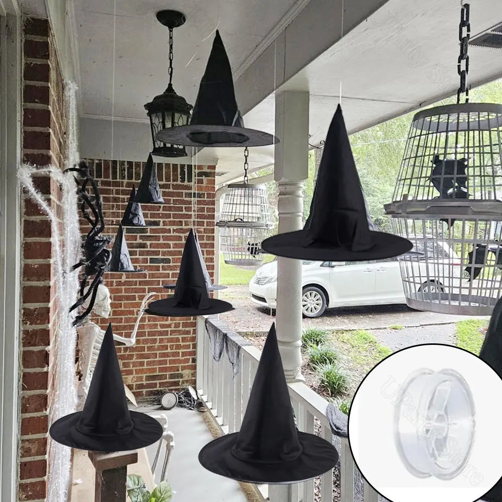 Black witch hats hanging on a Halloween-themed porch with spider webs.