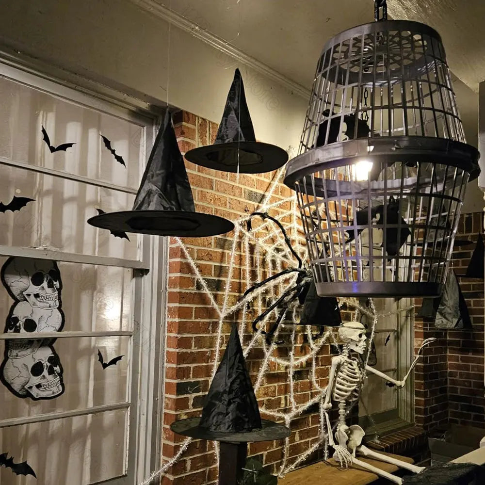 Halloween-themed decorations including witch hats, a skeleton, and spider webs on a brick wall.